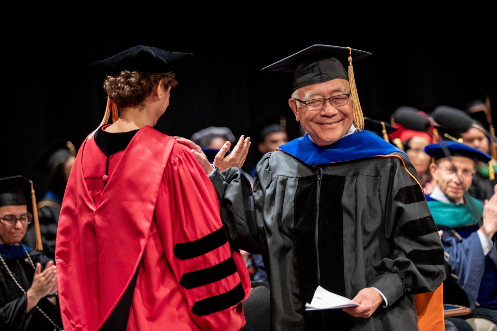 Keith Yamamoto greets Liz Watkins on stage at Grad Div Commencement 2019
