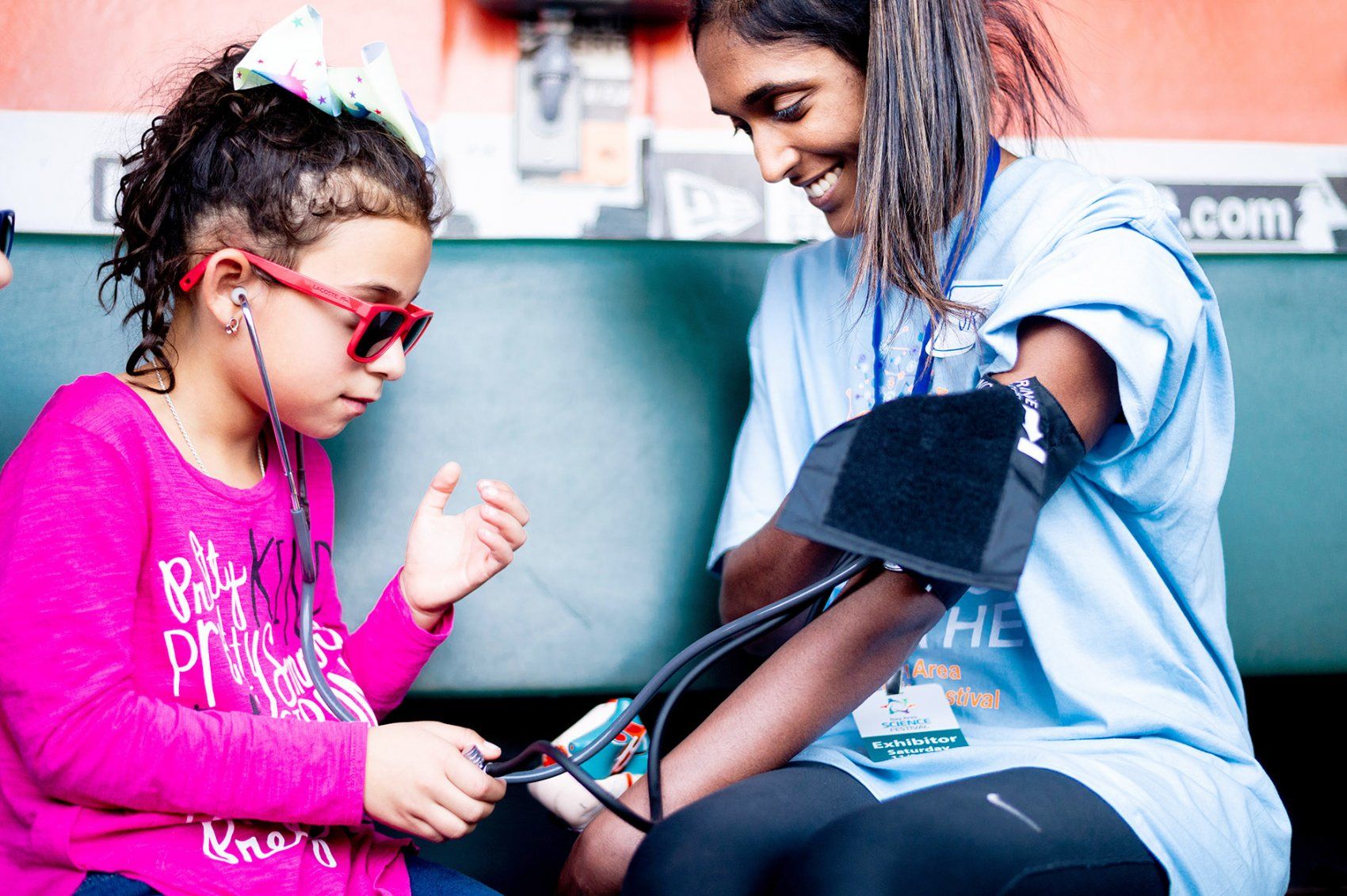 a girl takes a woman’s blood pressure