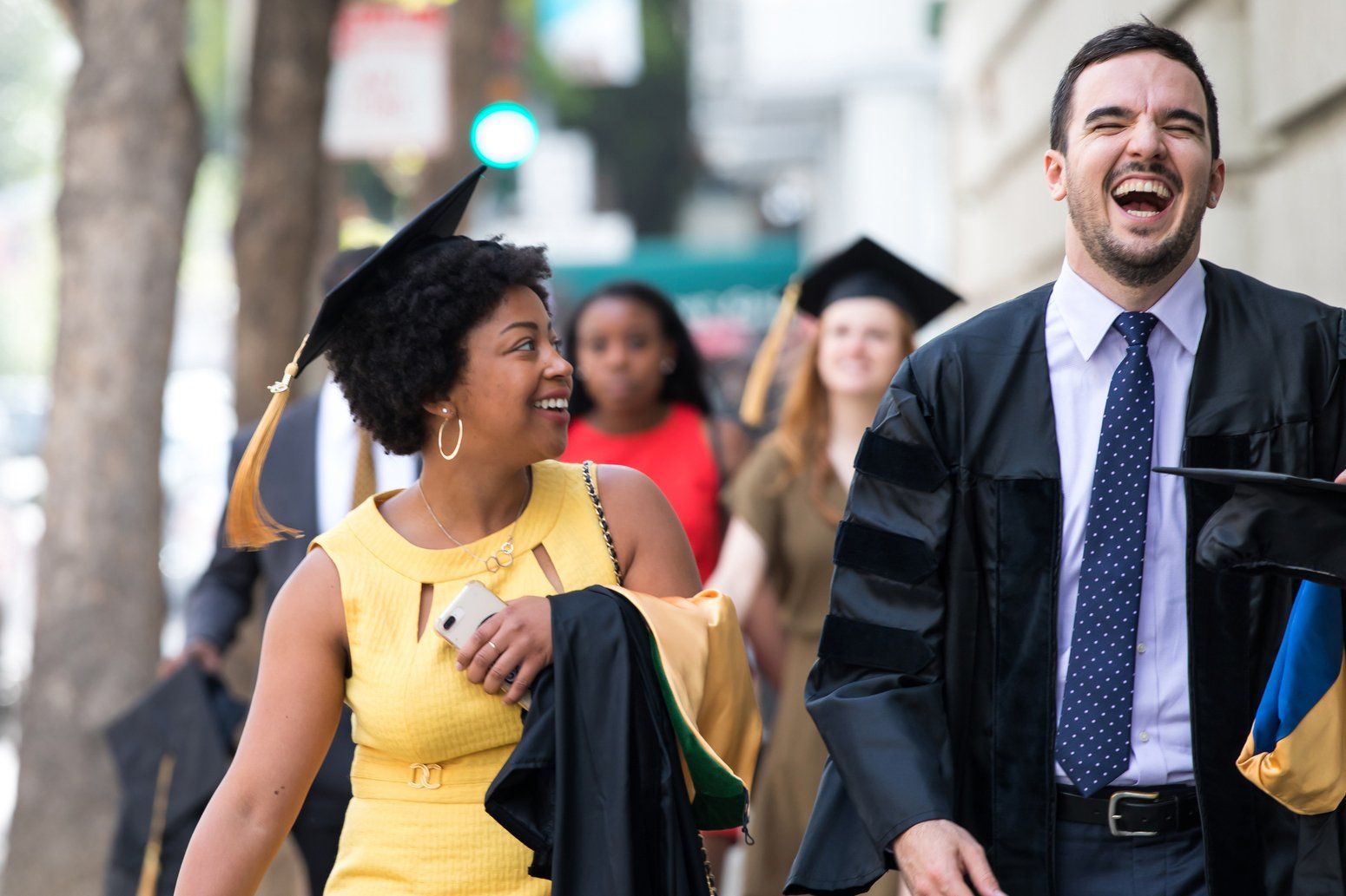 Two students walking and laughing before graduation