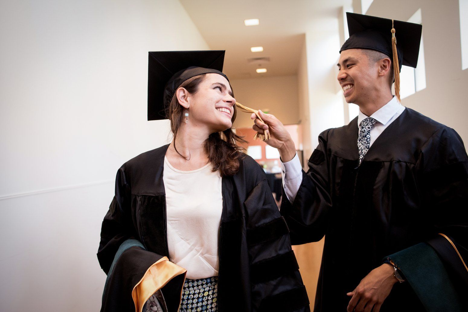 Two students wearing graduation robes