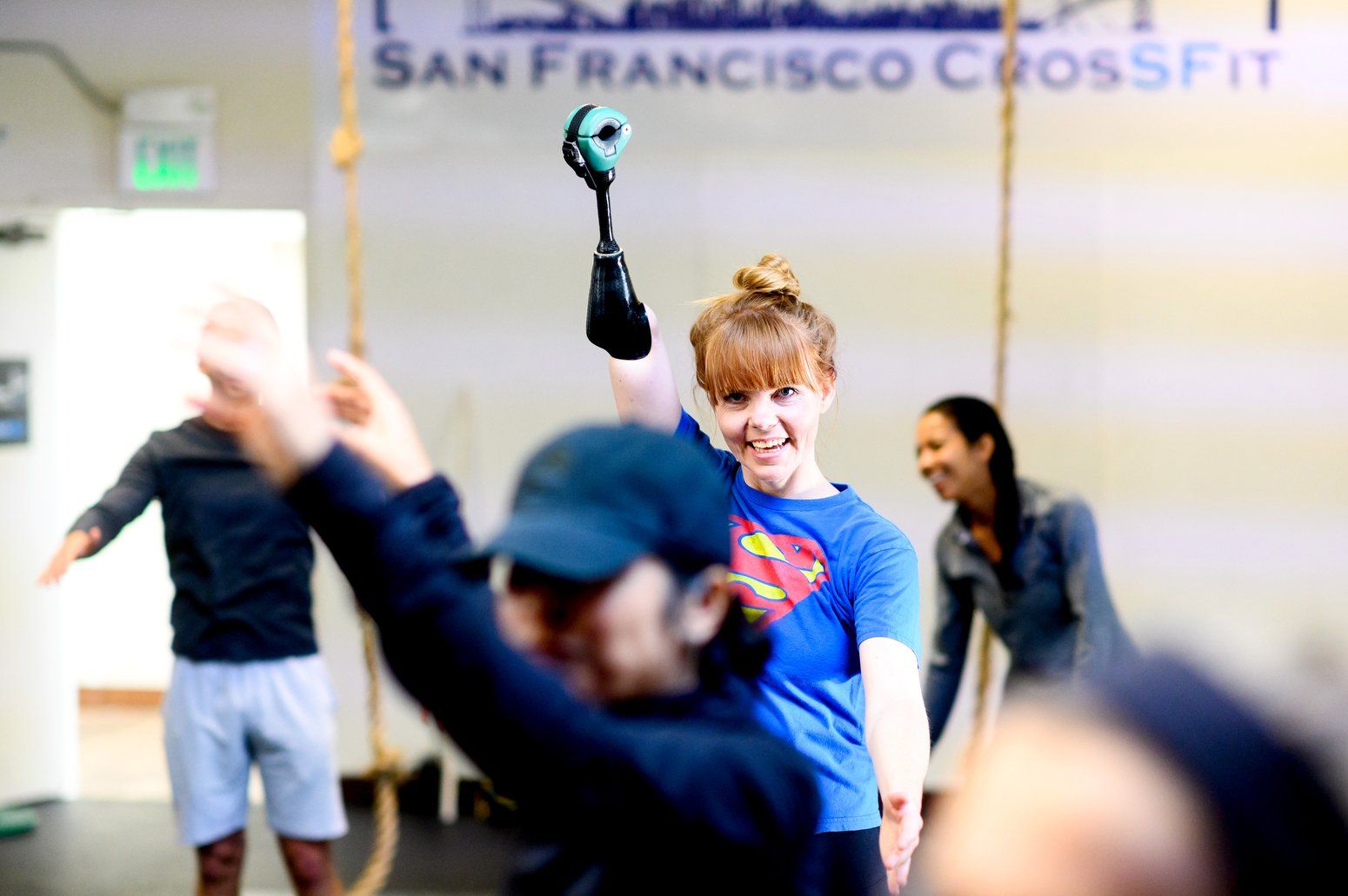 Woman raising prosthetic arm in gym