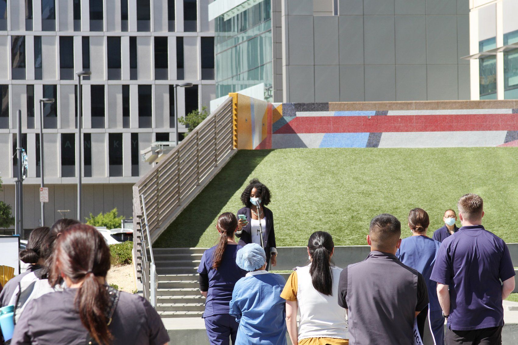 a woman speaks during a rally at the UCSF Mission Bay Medical Center