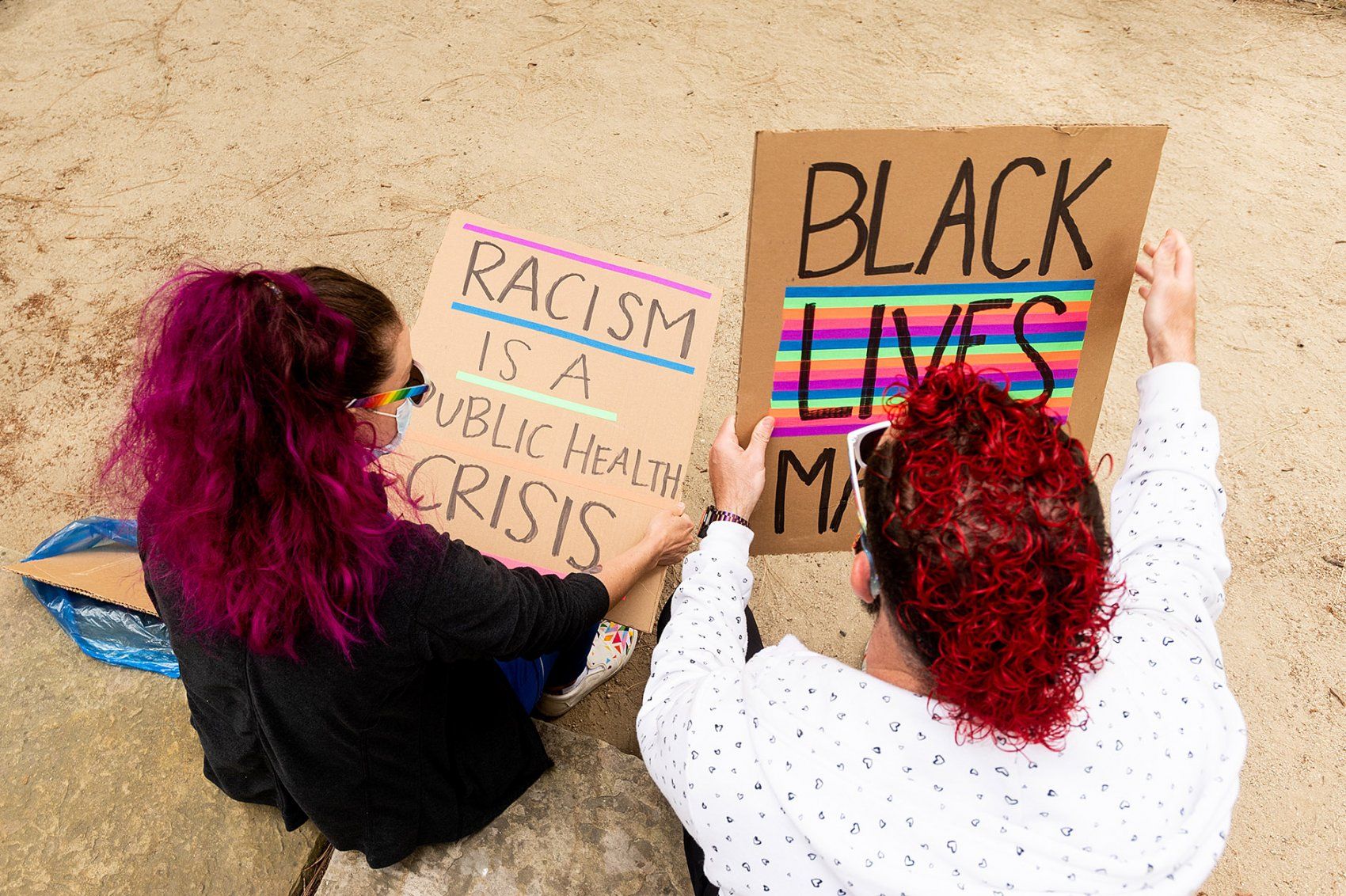 two people hold signs during rally
