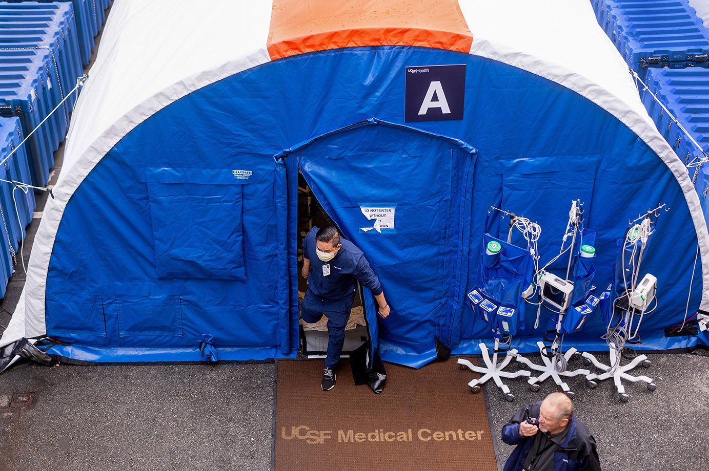 A medical worker exists a COVID screening tent erected outside the hospital at the Parnassus campus