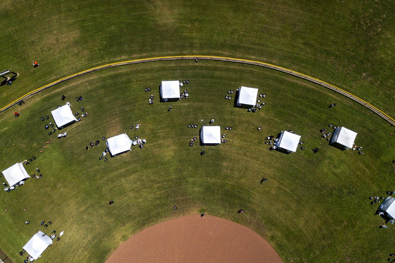 An overhead view of COVID-19 testing tents scattered across a baseball field