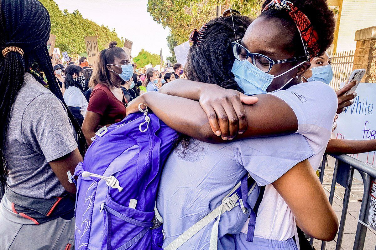 Two medical workers hug during a Black Lives Matter protest