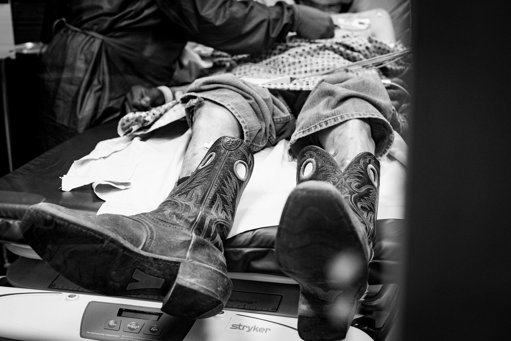patient with cowboy boots on lies on a triage medical table