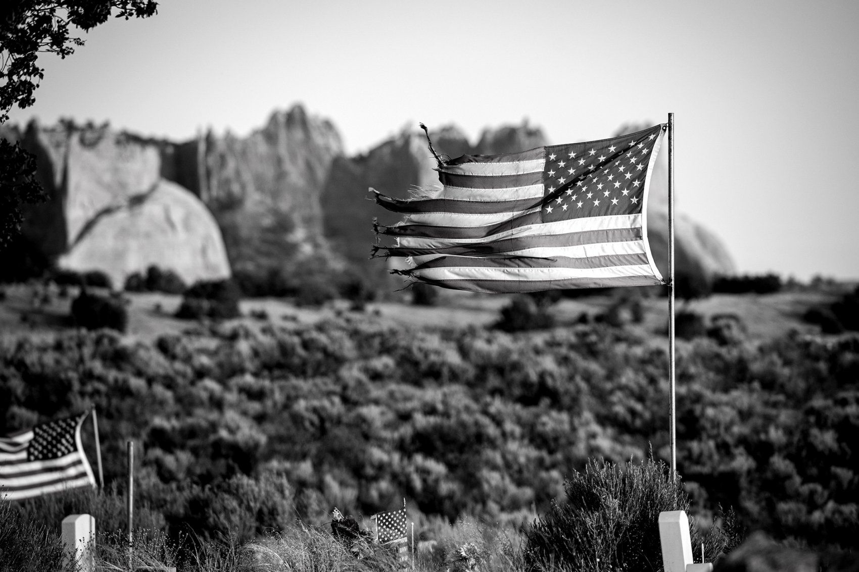 tattered flag flies over a cemetary