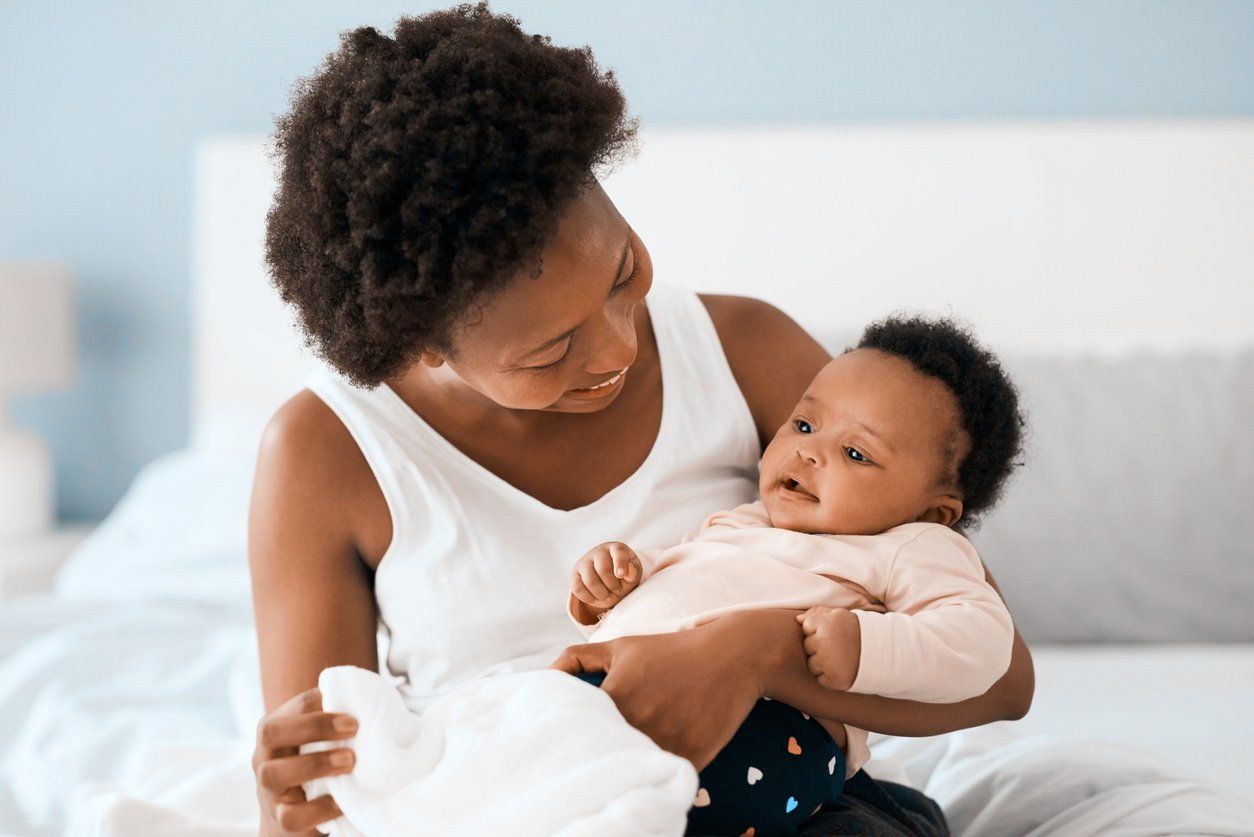 Black mother holding her baby, smiling