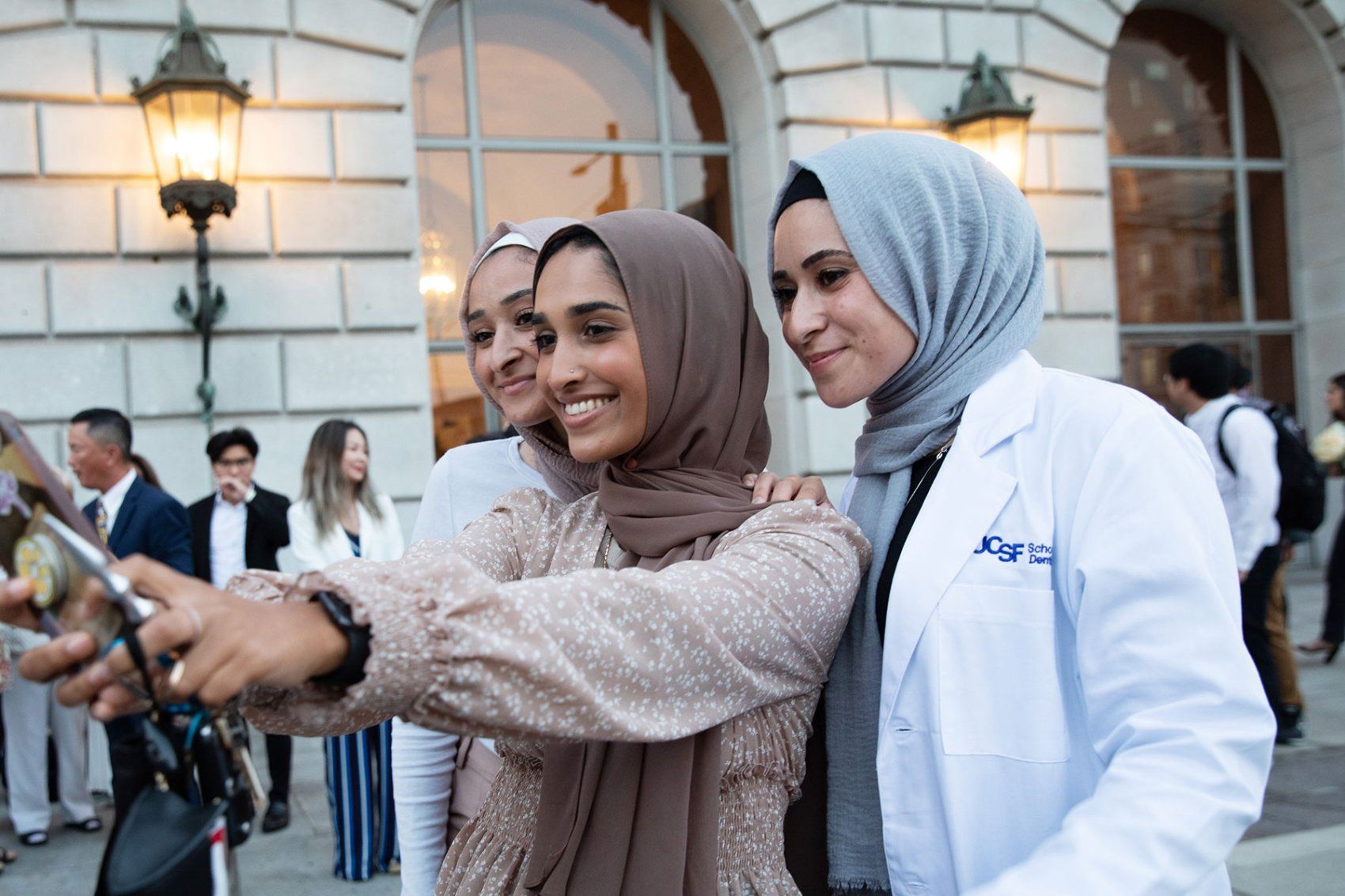 A new dentistry student on the right poses with two women for a selfie