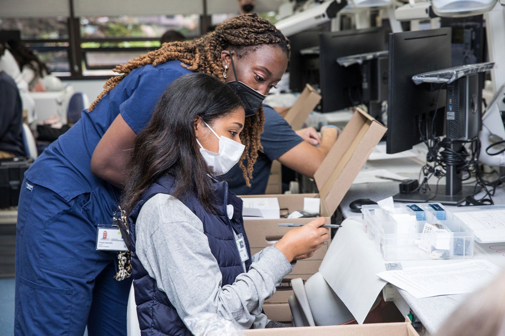 Two dentistry students who are Black women look through dental supplies
