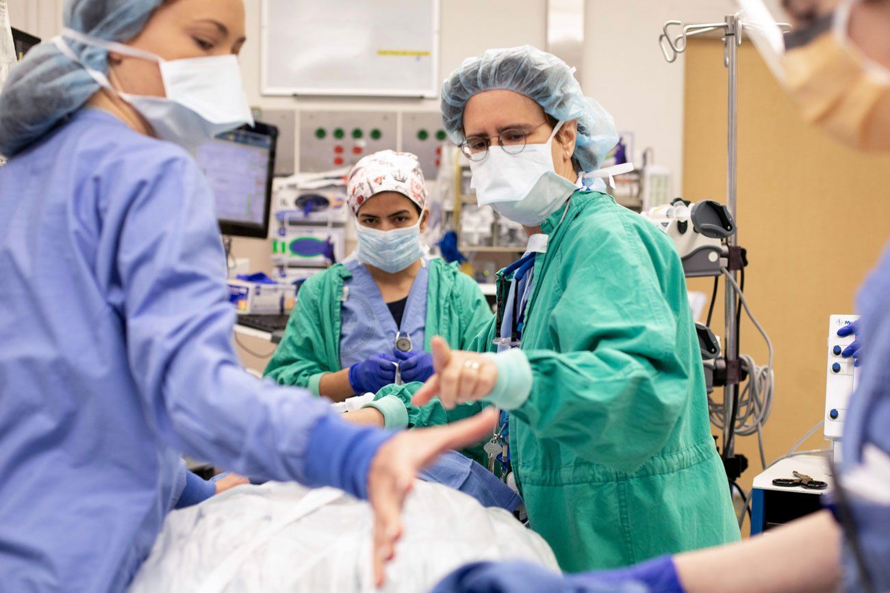 A group of medical professionals in scrubs prepare for surgery