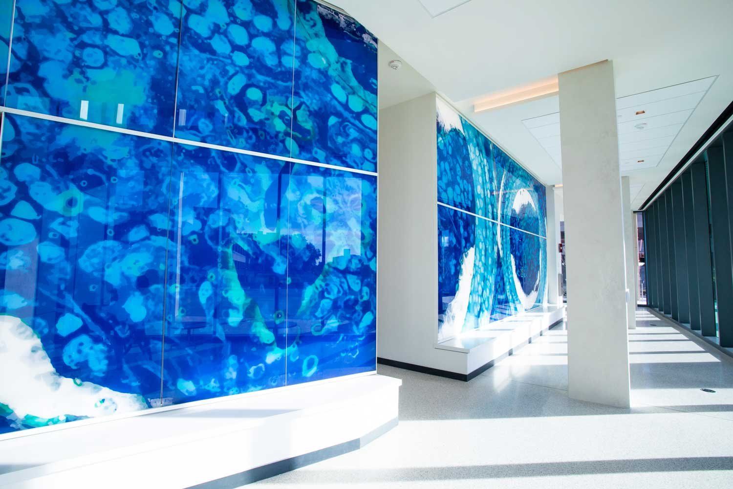 A wall at the NextGen Precision Health Institute in Columbia, Missouri, features panels of blue hues that resemble a microscopic image as part of the Enduring Impermanence art piece.