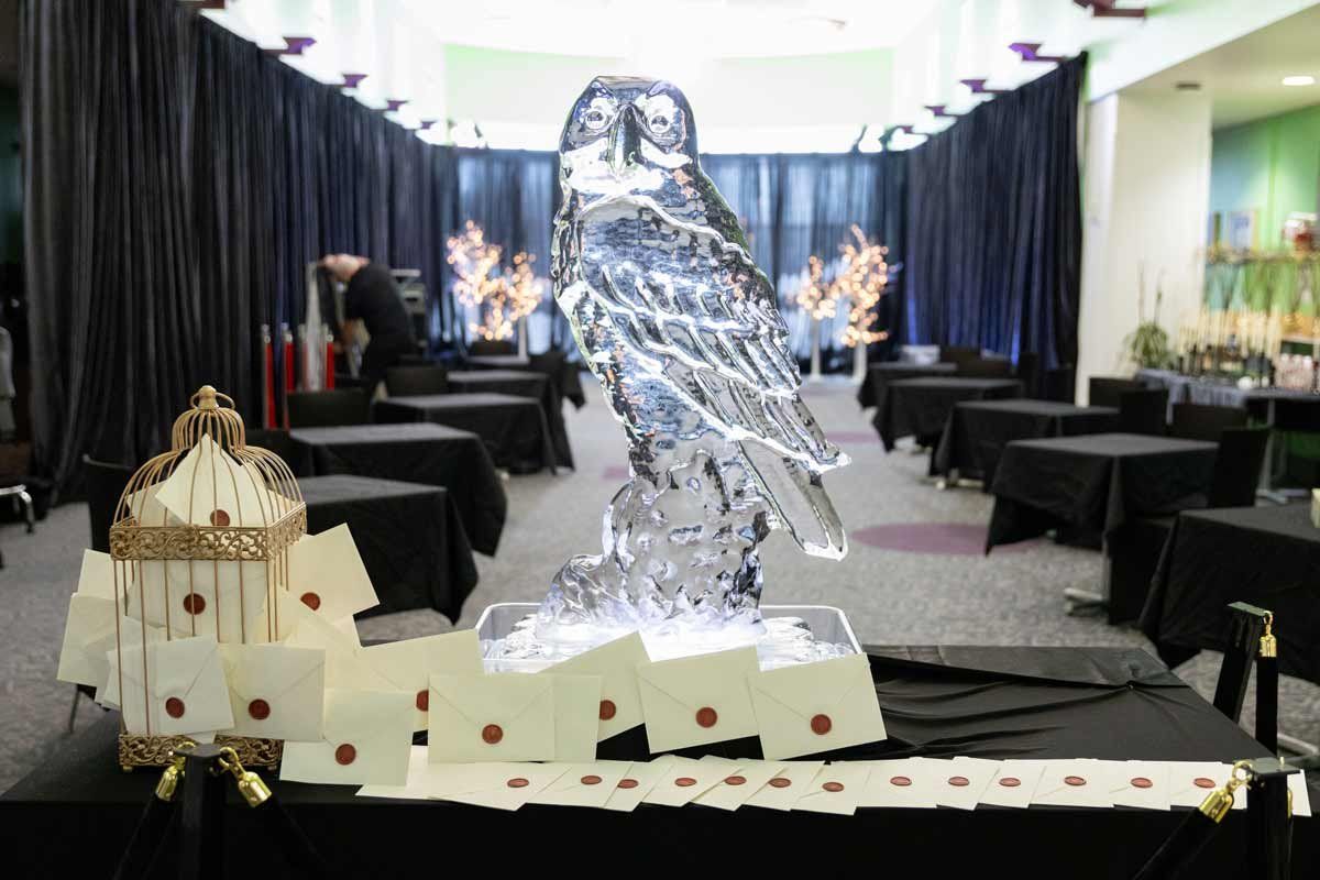 An ice sculpture of Hedwig the owl from Harry Potter, along with a decoration of Hogwarts letters coming out of a golden cage.