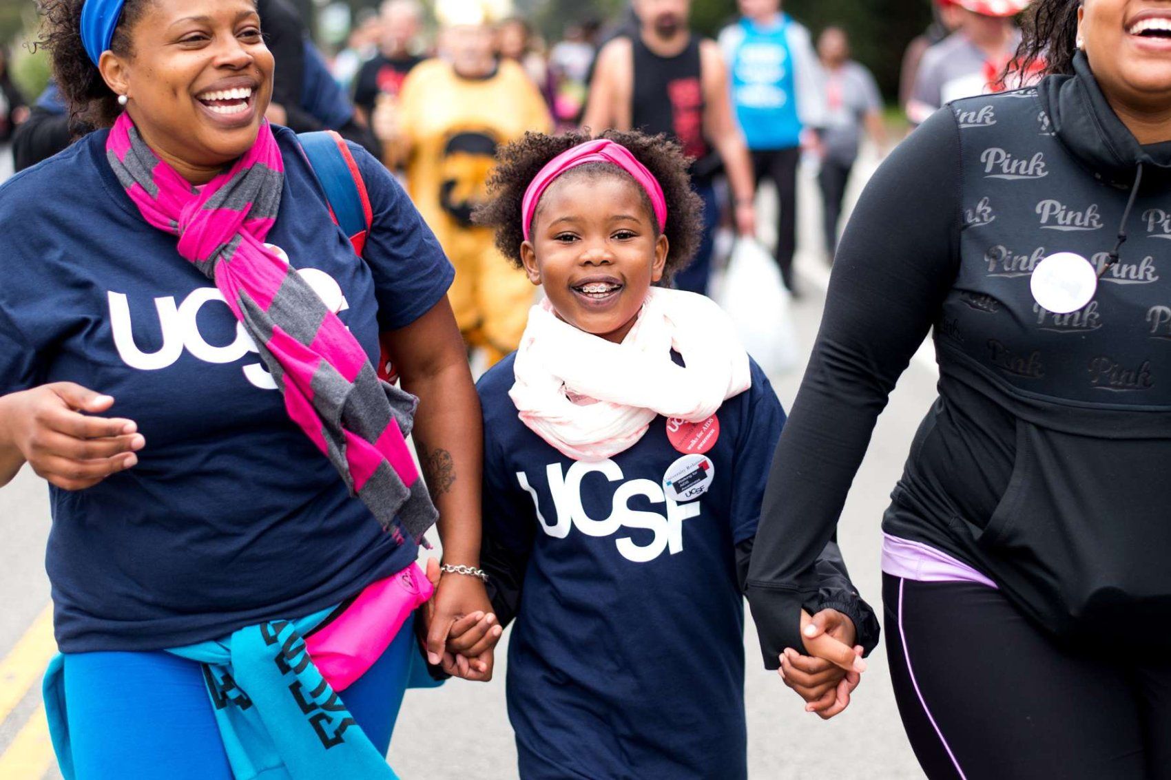 A young black girl walking with two black women in the AIDS Walk
