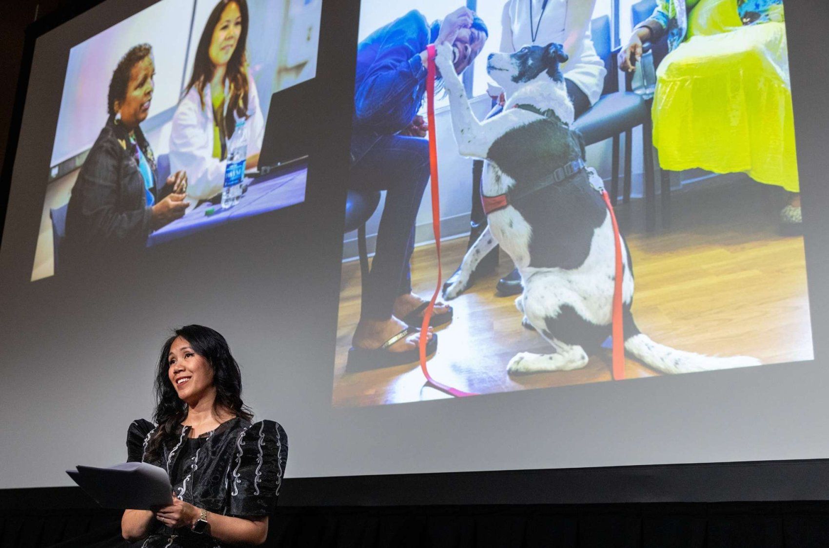 Dr. Jennifer Cocohoba presents a slide of a service dog comforting a patient.