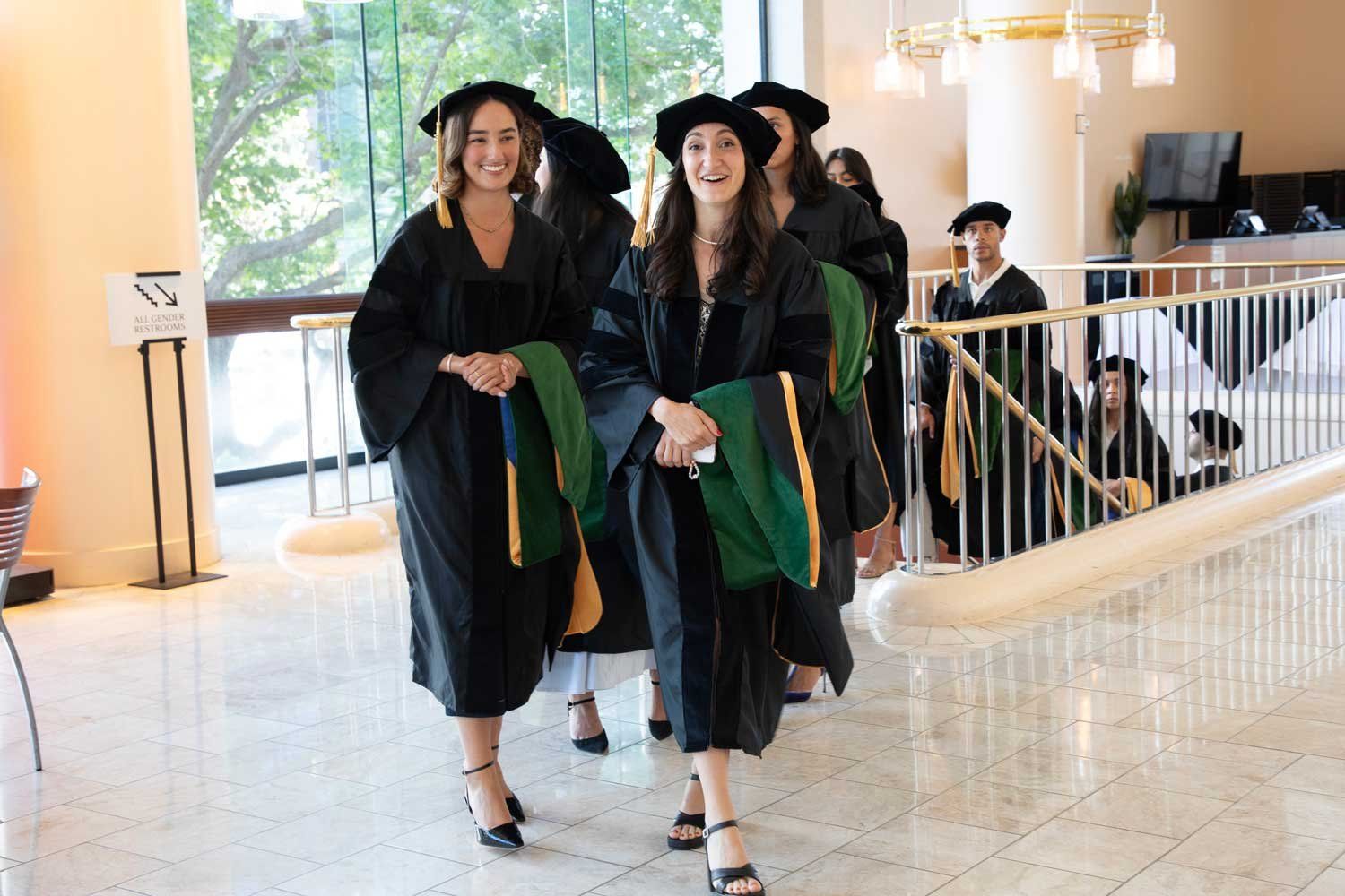 School of Medicine graduates Gabriela Gutierrez and Yagmur Halezeroglu in cap and gown.