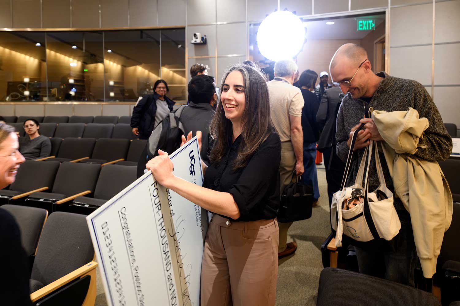 First-place winner Yolanda Marti Mateos carries a large check.