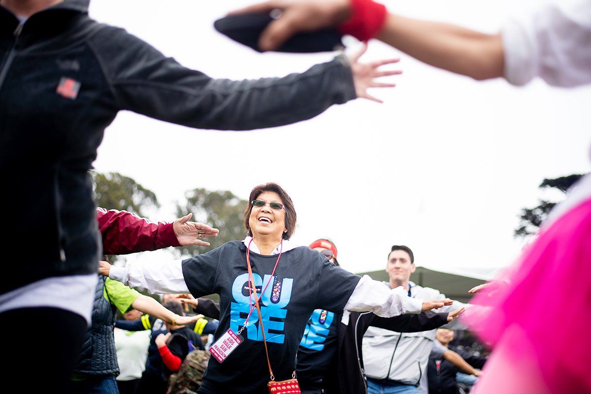 Dely De Vera warms up with fellow UCSF community members before the start of AIDS Walk San Francisco