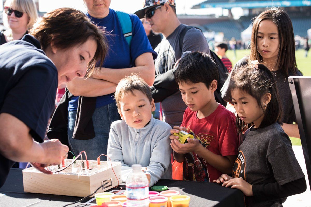 Kids are watching the presentation about electricity at the Bay Area Science Festival’s Discovery Day