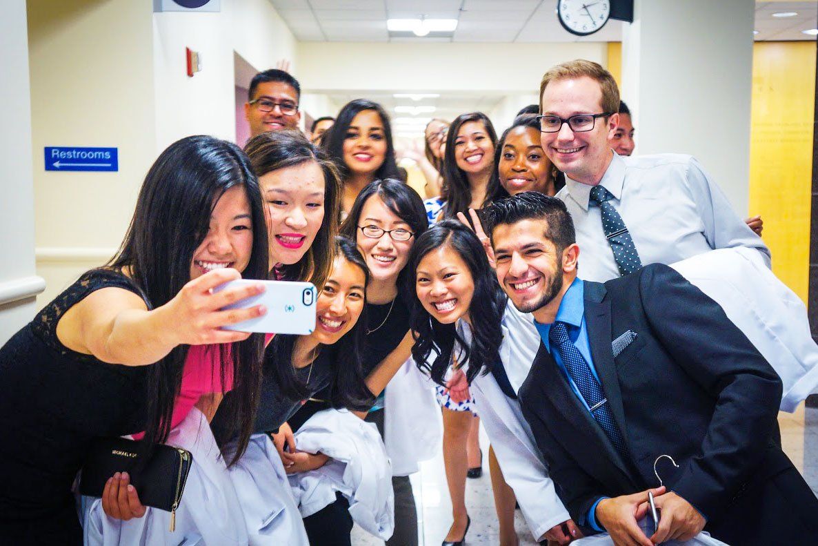 A group of pharmacy students pose for a selfie after their White Coat Ceremony