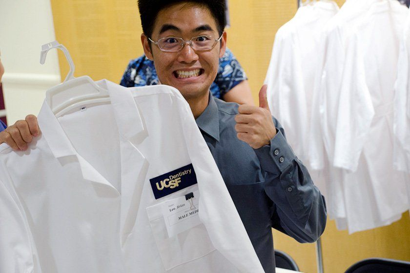 First-year dentistry student Brian Lee makes a nervous grin as he holds up his white coat