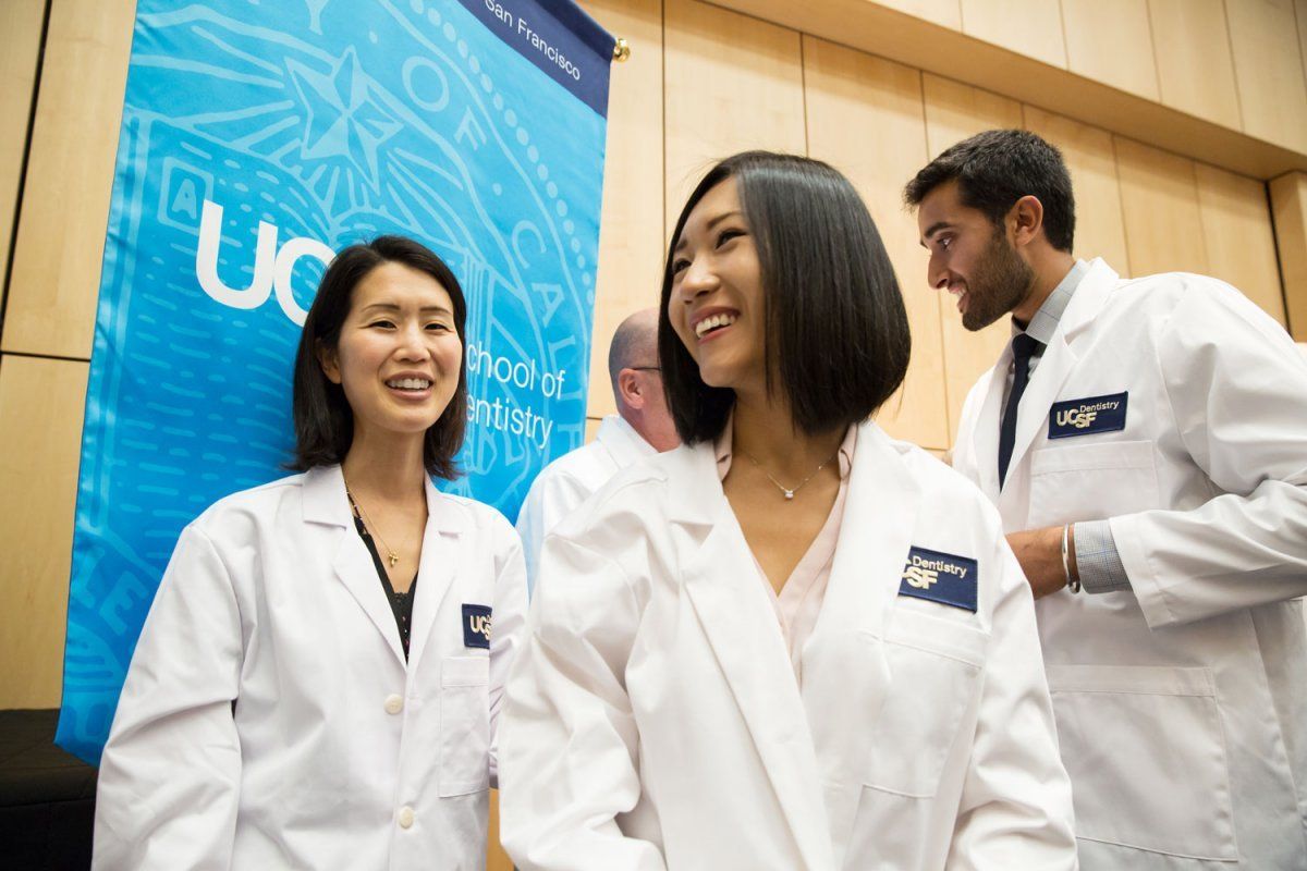 Chang Guo and Arvin Pal smiling in their new coats after the School of Dentistry White Coat Ceremony
