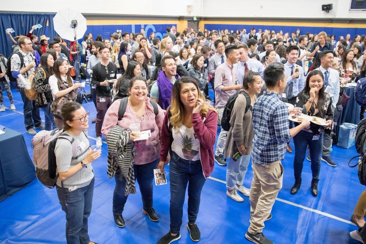 A big group of students is mingling and enjoying food during Chancellor’s Reception for First-Year Students