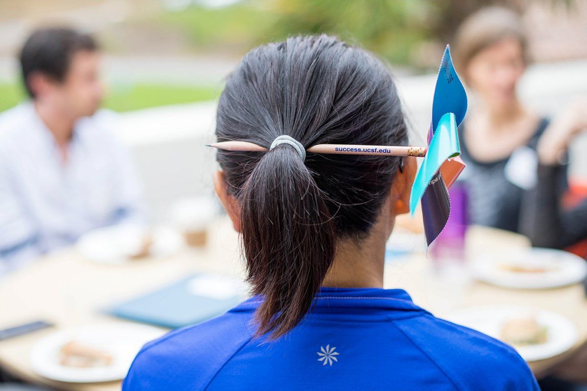 Festive “Success.ucsf.edu” pinwheel pencil is used by a student as a hairpin