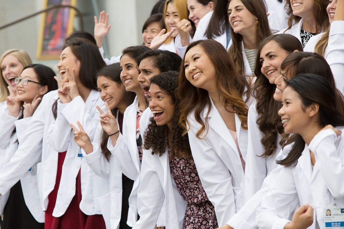 New UCSF School of Medicine students pose for a photo in their white coats
