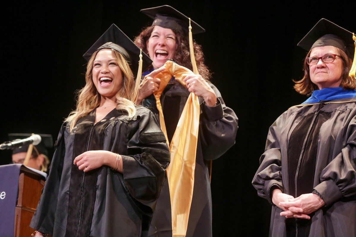 Nicole Garlit is hooded by Kimberly Topp, Phd, PT, at the Graduate Division commencement ceremony