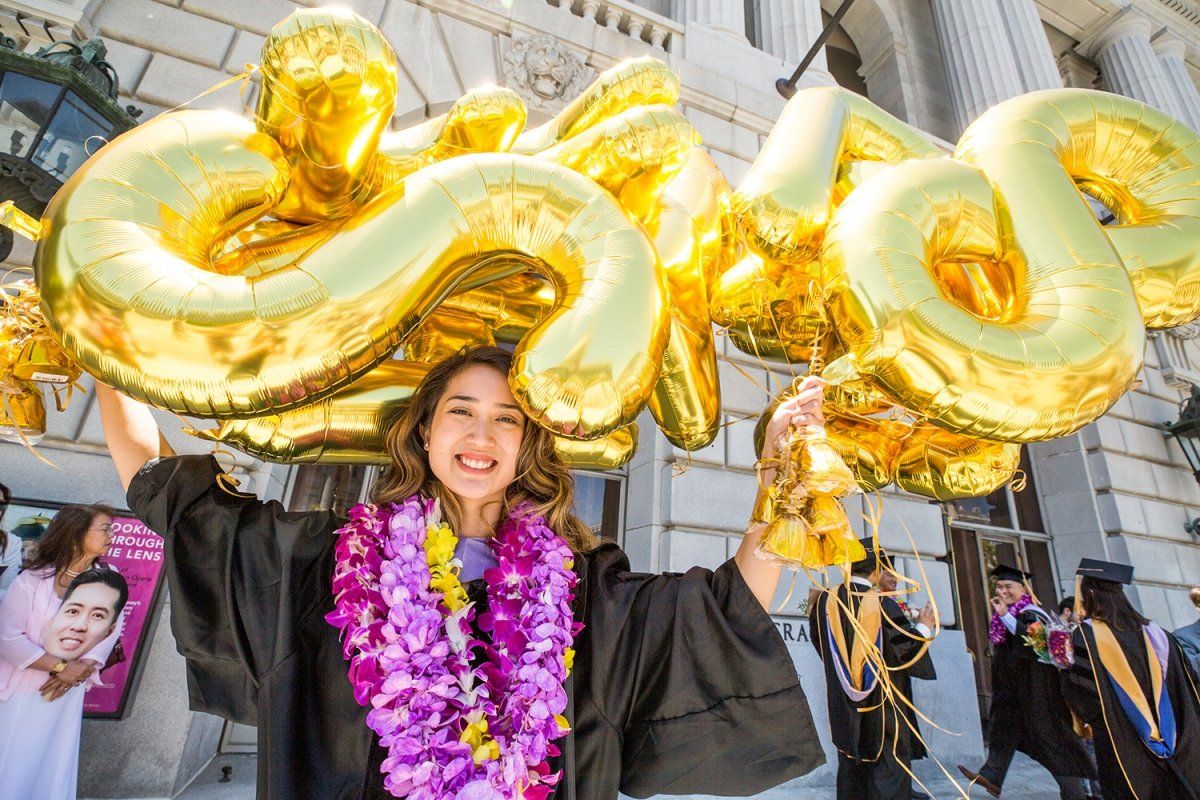 Esther San Nicolas holds balloons after the School of Dentistry commencement ceremony