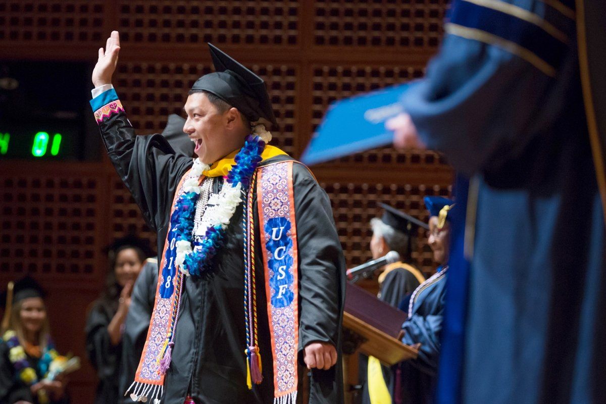 Chi Vang waves to the crowd during the UCSF School of Nursing commencement ceremony