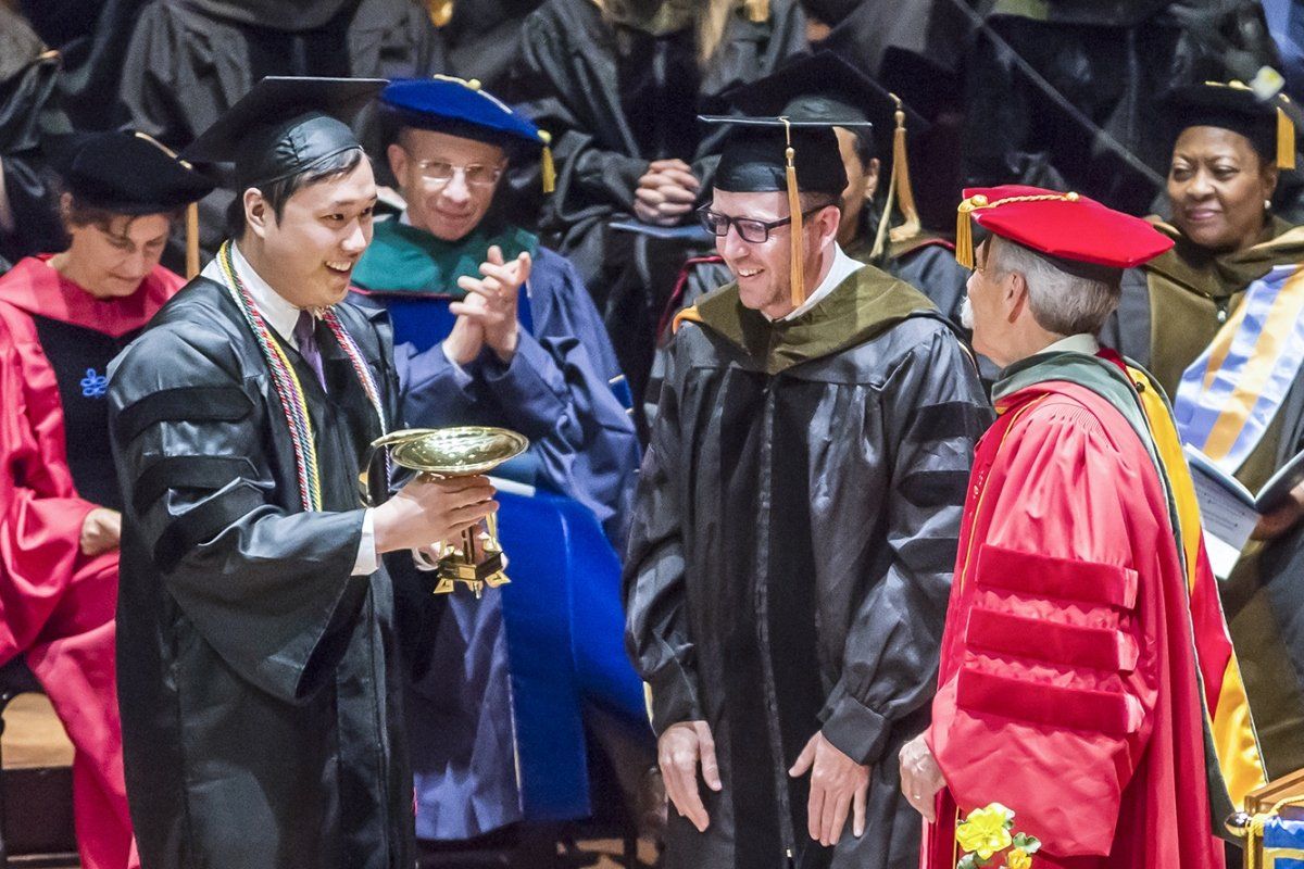 Kenneth Tham (left) receives the Bowl of Hygeia Award for community service during school’s commencement ceremony