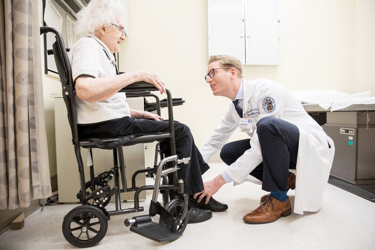 Doctor is examining a woman in the wheelchair