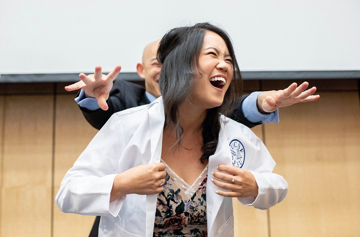 Waing Noe, a student in the three-year Physical Therapy program, which is a joint program with UCSF and San Francisco State University, receives her white coat from Kenneth Leung, DPT, assistant clinical professor of Physical Therapy