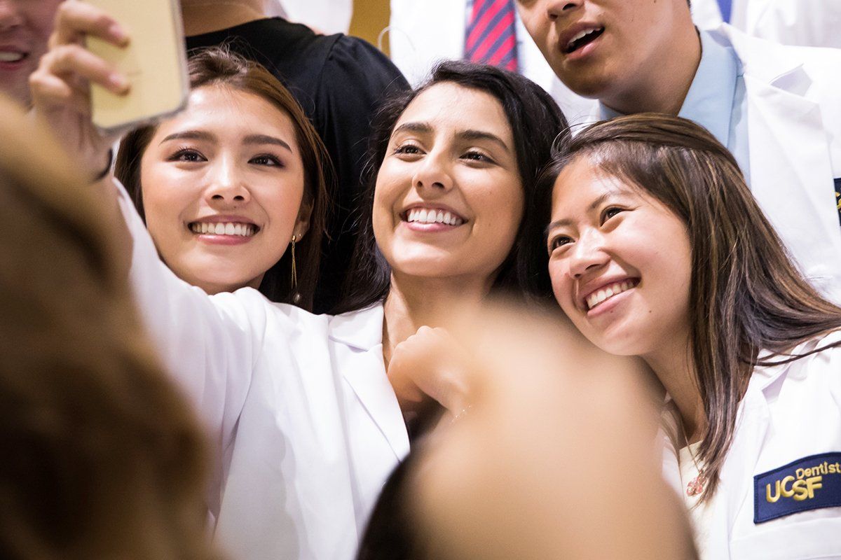 New UCSF School of Dentistry students Susan Keefe, Lori Martinez-Rubio and Ivan Chan take a selfie during the school’s white coat ceremony