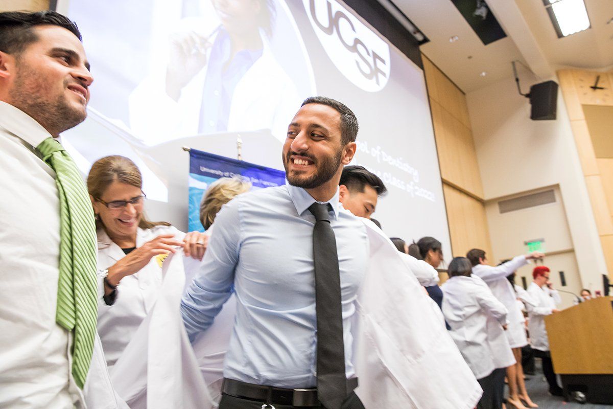 School of Dentistry student Fady Ibrahim receives his white coat from Nejleh Abed, DDS, during the school’s white coat ceremony