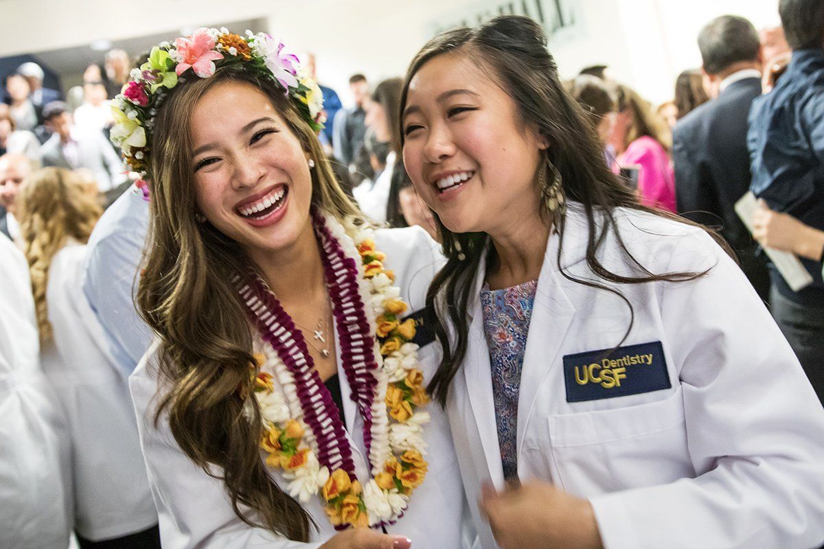 New School of Dentistry students Yating Young and Theresa Bui celebrate after the school’s white coat ceremony
