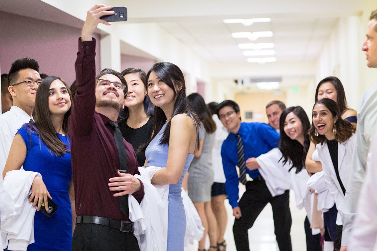 Bryan Herrera takes a selfie with his new School of Pharmacy classmates before the school’s white coat ceremony