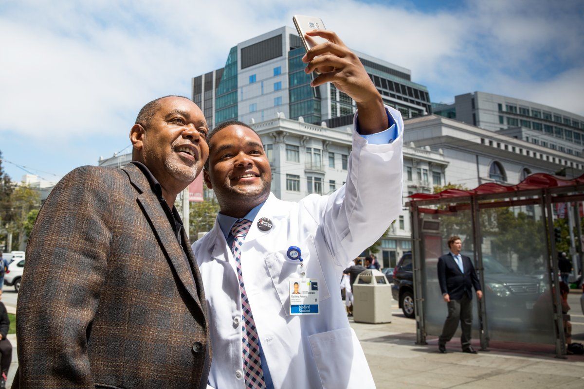 Matthew Roberts taking a photo in his white coat