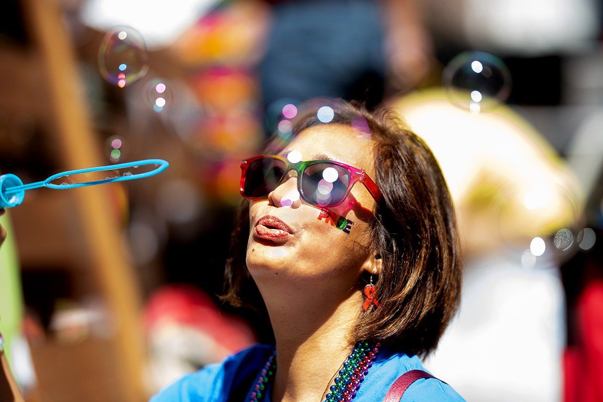 A woman in sunglasses blows bubbles