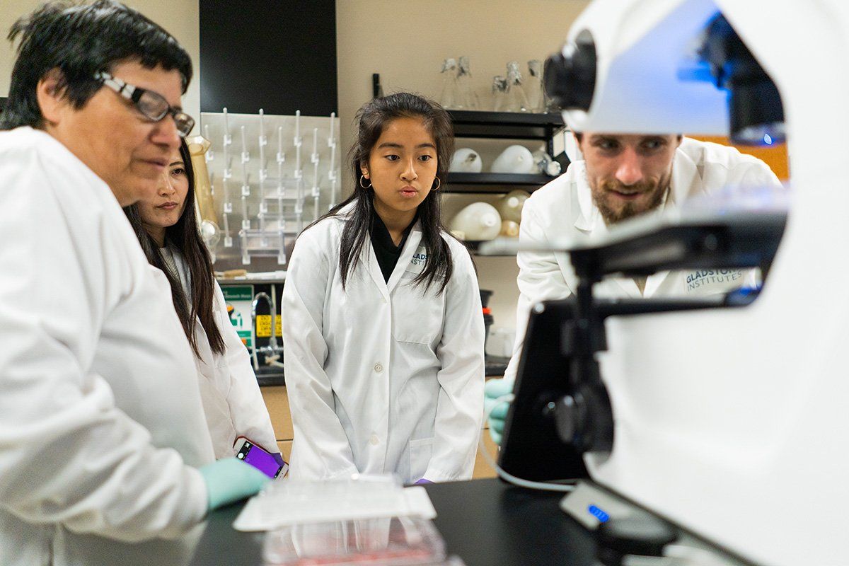 Patrick O’Leary, PhD, demonstrates green fluorescence under a microscope during a lab tour