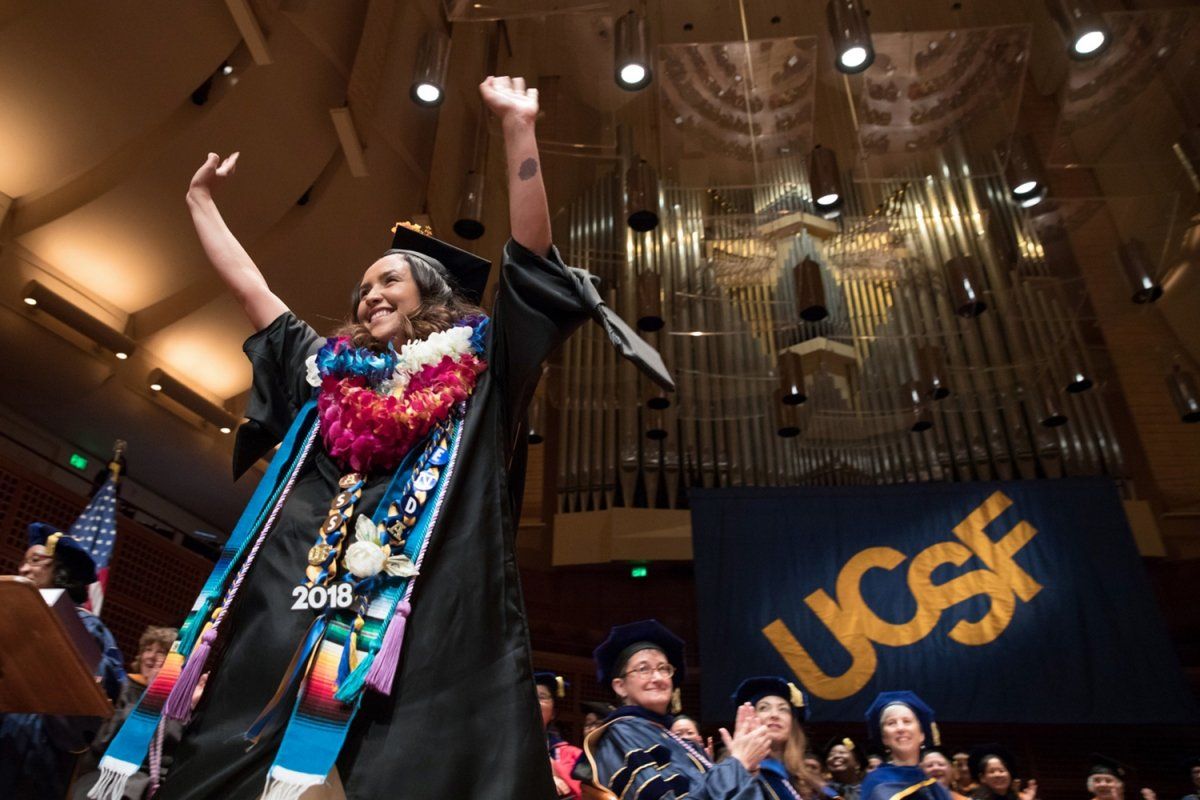 Gabriela Chica raises her arms in celebration at the School of Nursing commencement ceremony