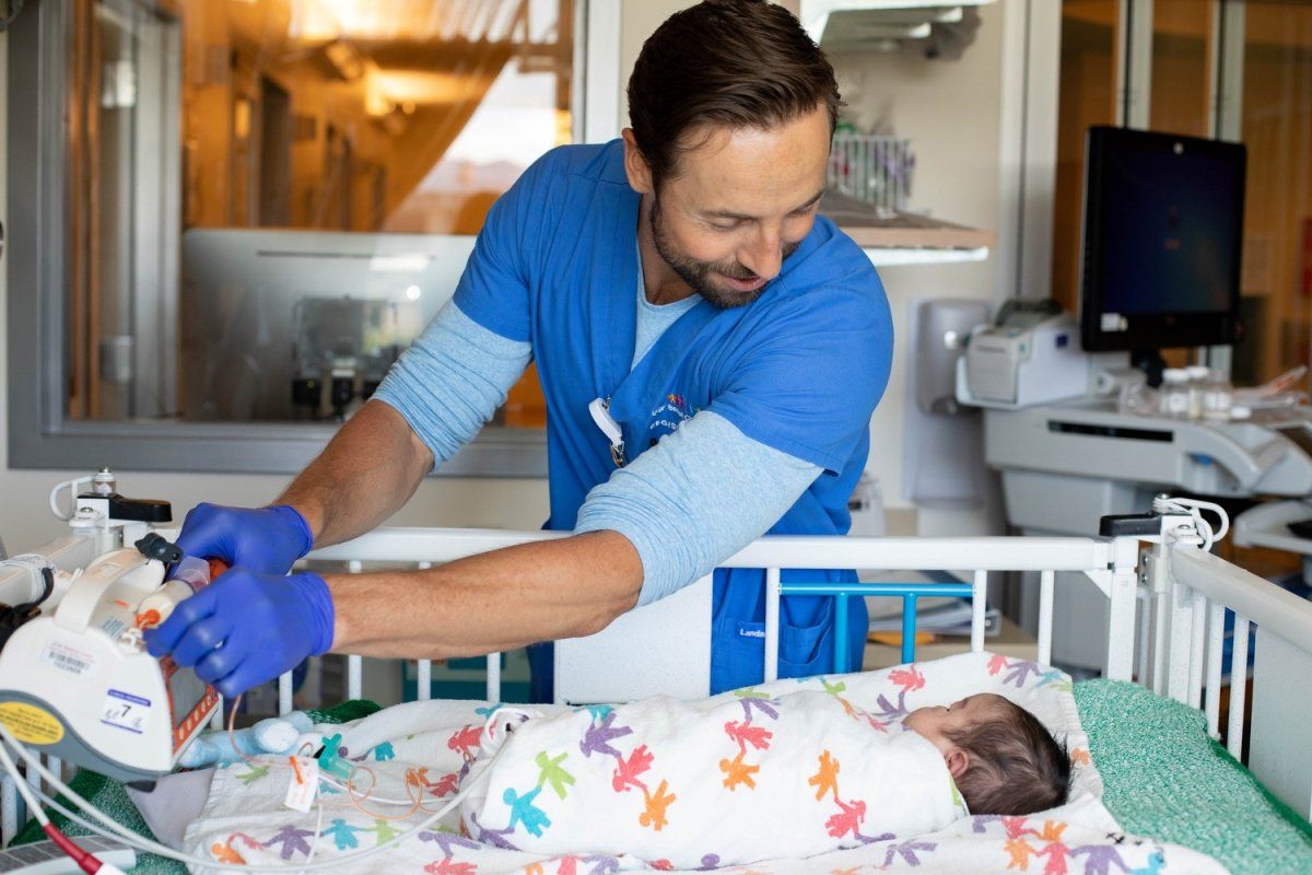 Ryan Grant, RN, a clinical nurse in the Pediatric Intensive Care Nursery, checks on his 15-day-old patient