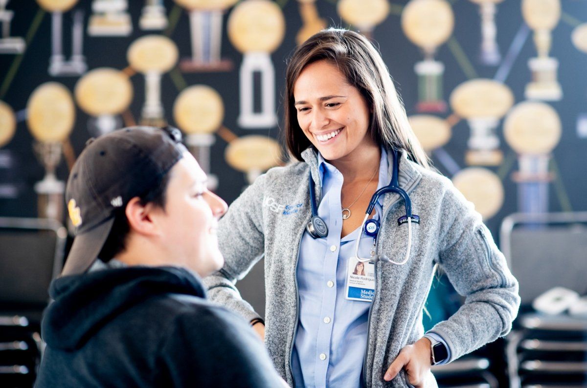medical student Nicole Rodriguez speaks with fellow medical student Alexis Velazquez