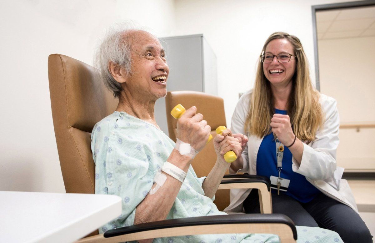 Stephanie E. Rogers, MD, cheers as her patient is holding weights during exercise class