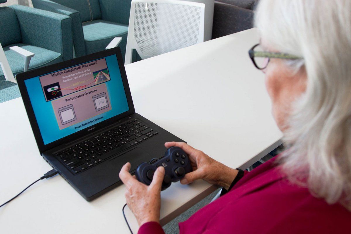 Elderly woman playing a racing video game on the computer