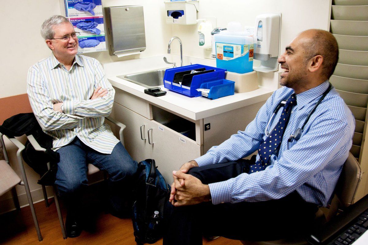 Oncologist Adil Daud, MD, checks in with a patient at UCSF Medical Center