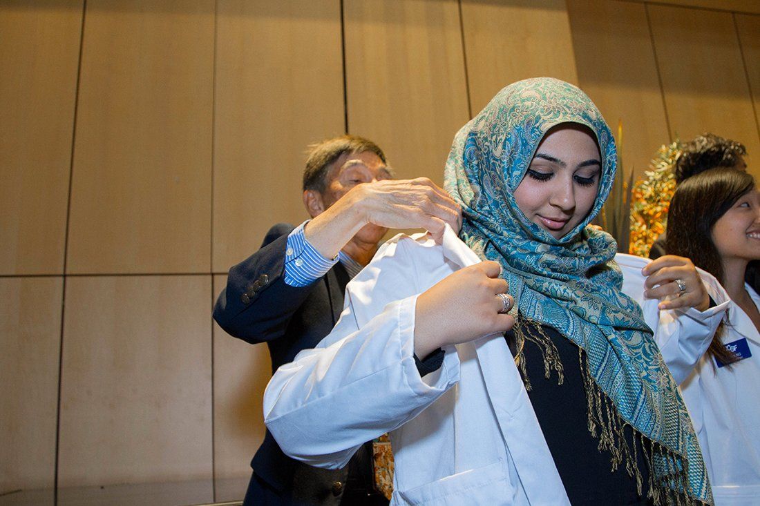 Class of 2018 Pharmacy student Tuba Nemati is white-coated by Glenn Yokoyama